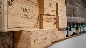 Wooden wine storage boxes with labels, stacked against a stone wall.