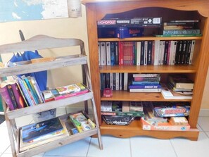 A bookshelf with various books and board games. - Mobile home with terrace for 4 people (Guégon)