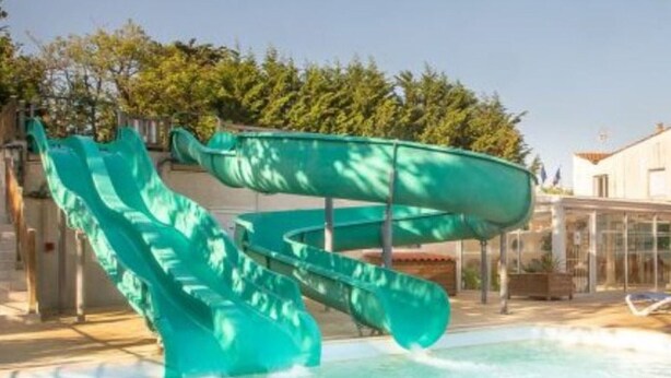 En swimmingpool med et grønt vandrutschebane.