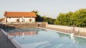 En swimmingpool med fri utsikt över en byggnad med ett rött tak i bakgrunden.