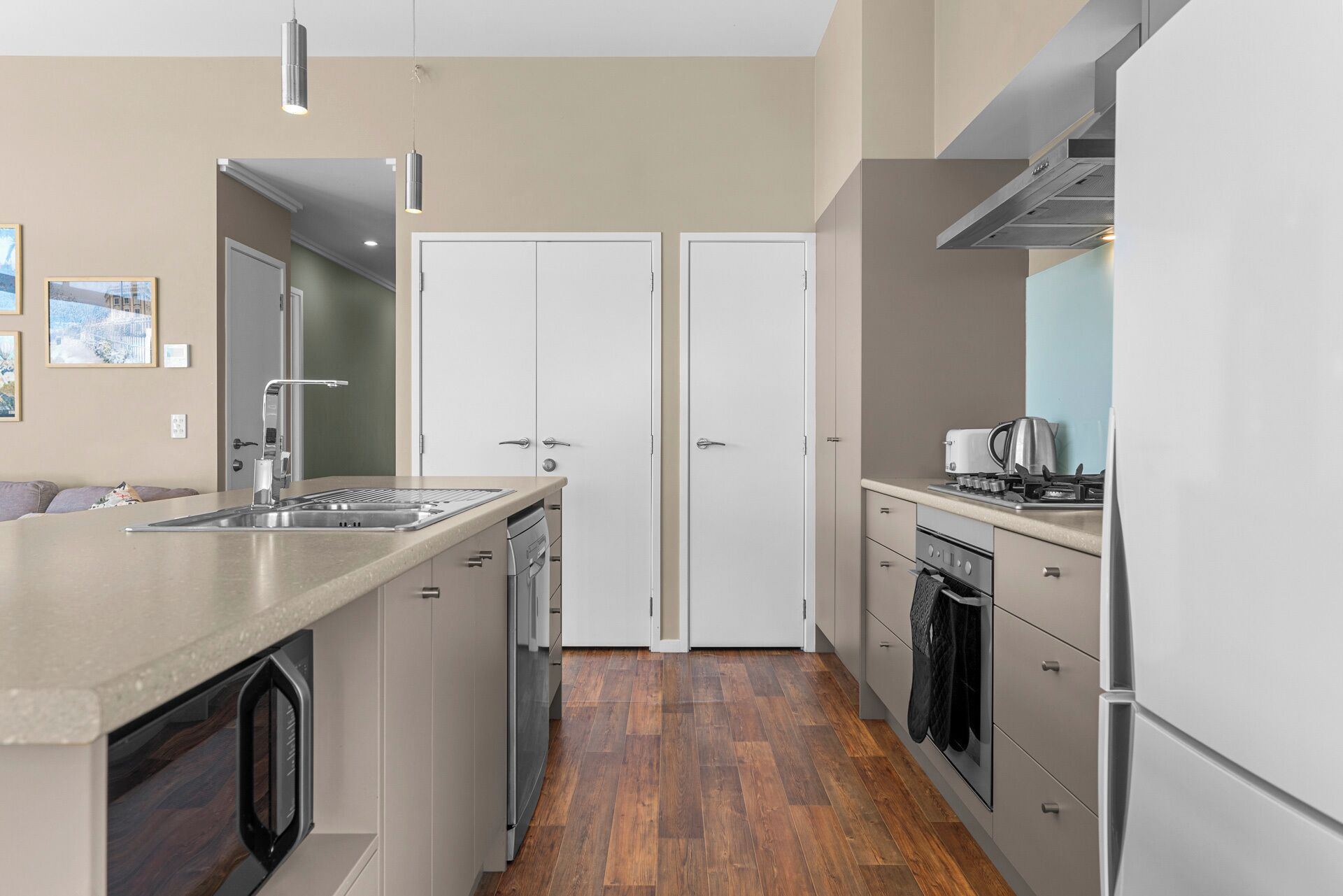 Una cocina moderna con una isla central, electrodomésticos de acero inoxidable y suelo de madera.