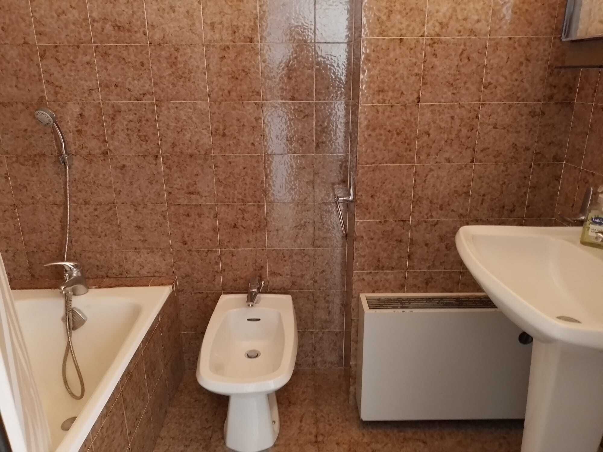 A bathroom with a bathtub, a bidet, and a sink.