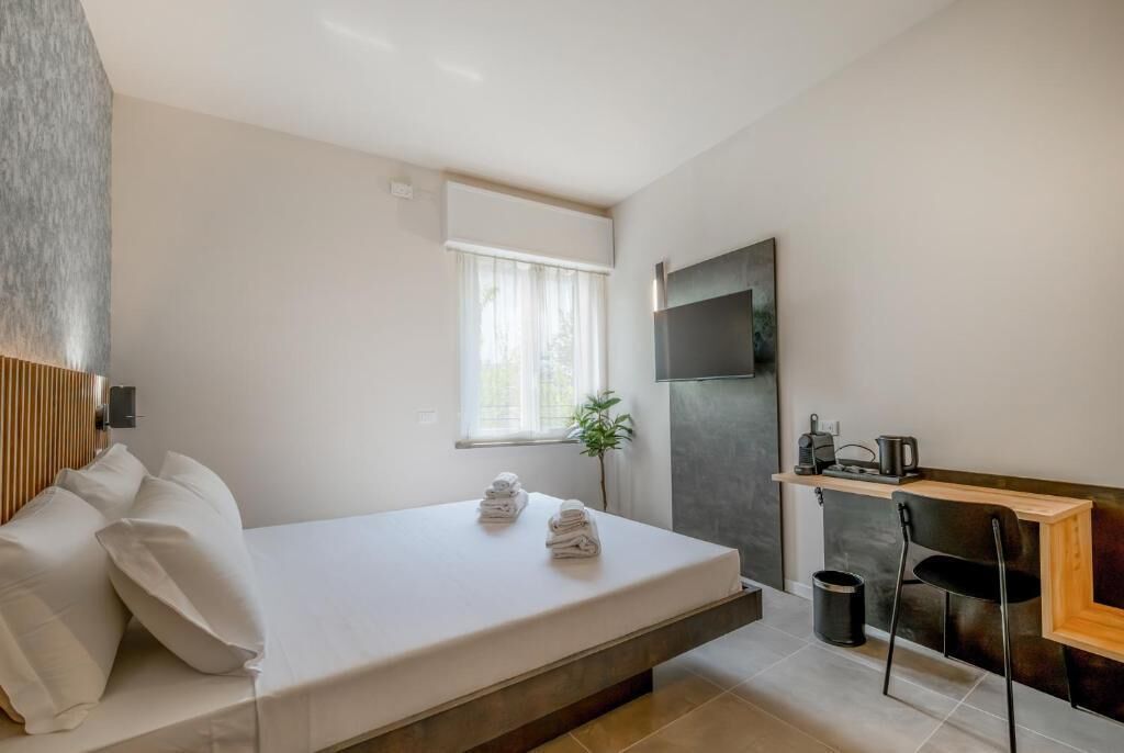 A modern room with a bed, a desk, and a TV.