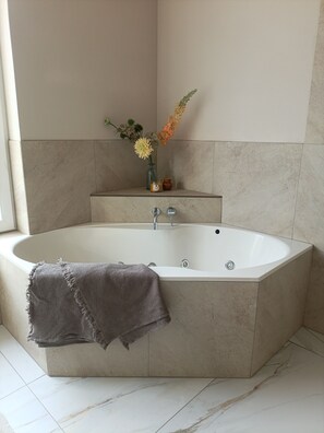 Regadera, tina de hidromasaje, secadora de cabello, toallas