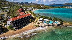 Un hotel frente al mar con piscina, acceso a la playa y vistas al océano.