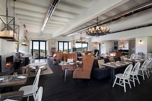 A spacious indoor area with a fireplace, seating arrangements, and a view through large windows. - Argentario Golf Villas (Monte Argentario)