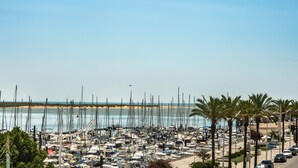 A marina with numerous boats docked, a sandy beach, and palm trees lining the area. - Charm & history in the heart of VRSA (Vila Real de Santo António)