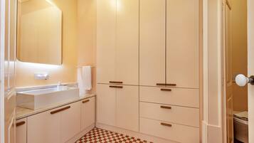 A bathroom with a checkered floor, a sink, and cabinets.