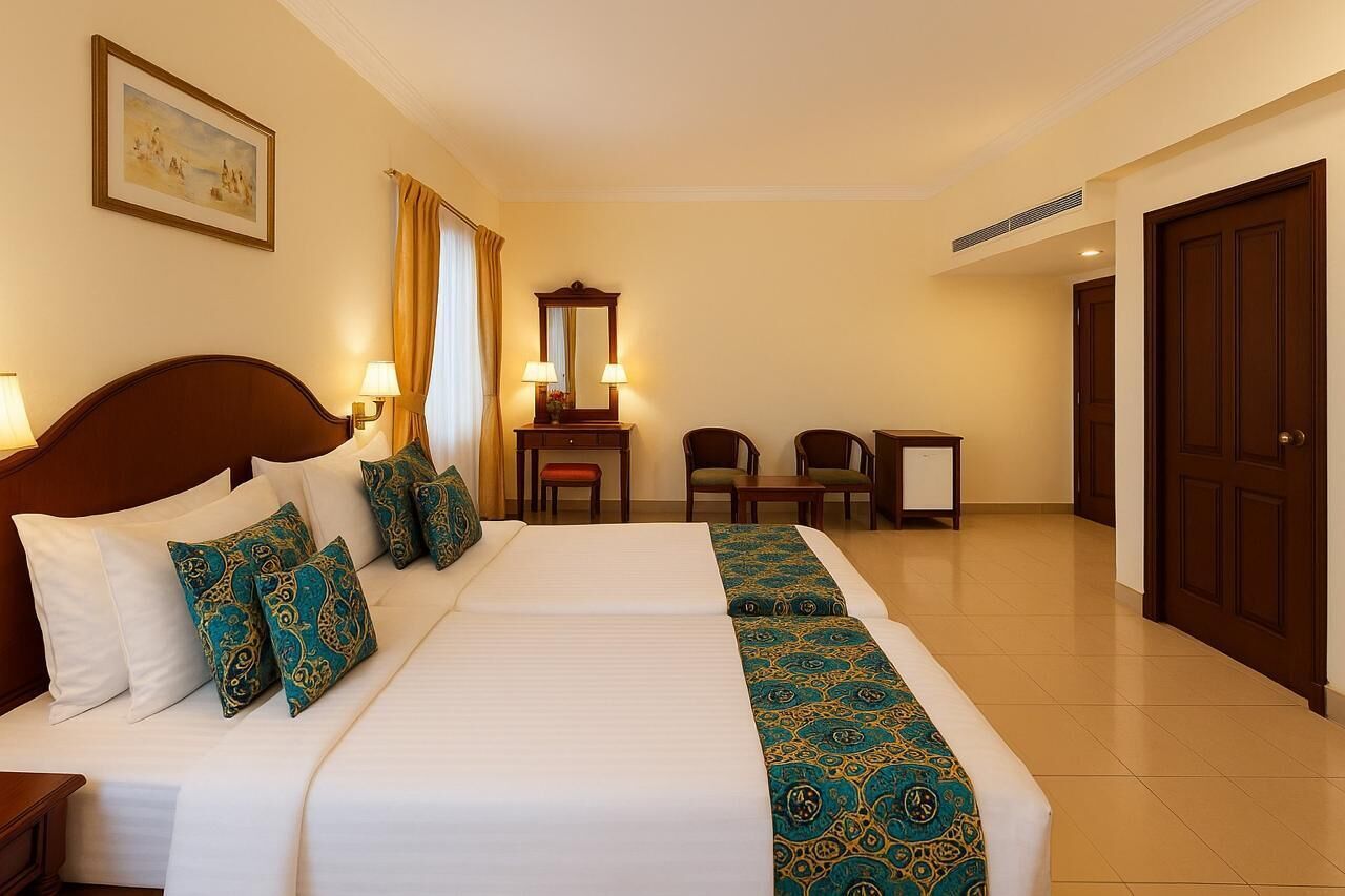 Een hotelkamer met een groot bed, twee nachtkastjes, een bureau, een stoel en een garderobe.