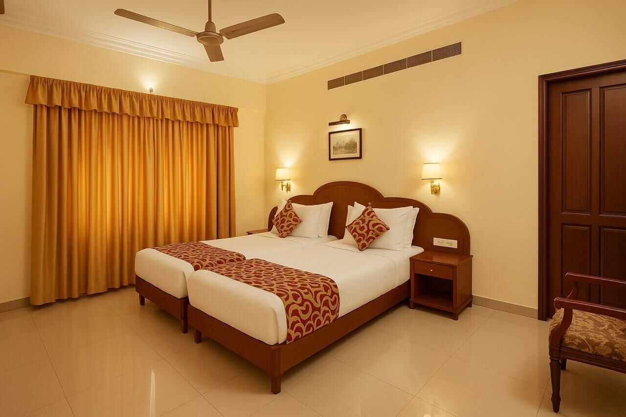 A hotel room with a double bed, two bedside tables, a nightstand, a chair, a ceiling fan, and a large window with curtains.