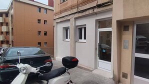 A building with a numbered door, a parked scooter, and a car. - Studio for 3 people - Bilbao (Bilbao)