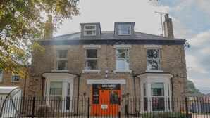 A two-story brick building with a prominent orange door labeled "Hollywood Rooms." - Hullywood Rooms (Hull)