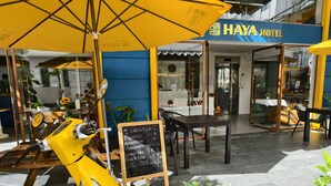 A yellow scooter parked outside a building with a sign reading "HAYA HOTEL". - Haya Hotel Da Nang (Da Nang)