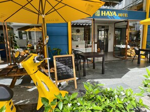 A yellow scooter parked outside a building with a sign reading "HAYA HOTEL". - Haya Hotel Da Nang (Da Nang)