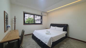Une chambre à coucher comprenant un lit, un bureau, une chaise, une fenêtre et un luminaire au plafond.