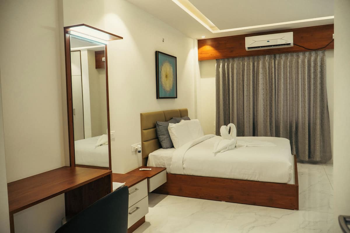 A modern bedroom with a wooden bed frame, a bedside table, a desk, and a chair.