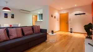 Una sala moderna con un sofá, una mesita redonda y una planta en maceta.