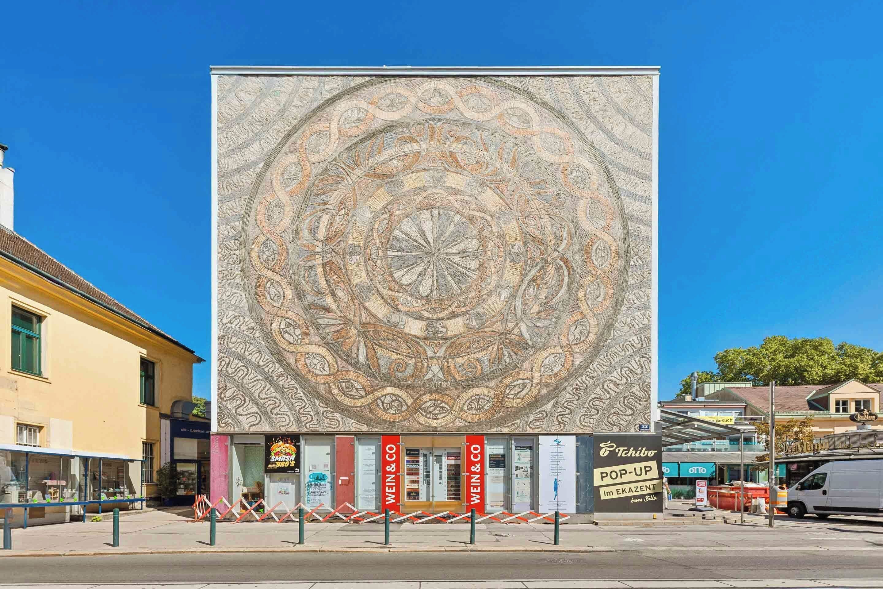 A building facade with a large circular mosaic design.