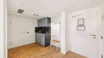 Eine moderne Küche mit grauen Schränken, einer Holzausziehtafel und einer kleinen Bank.