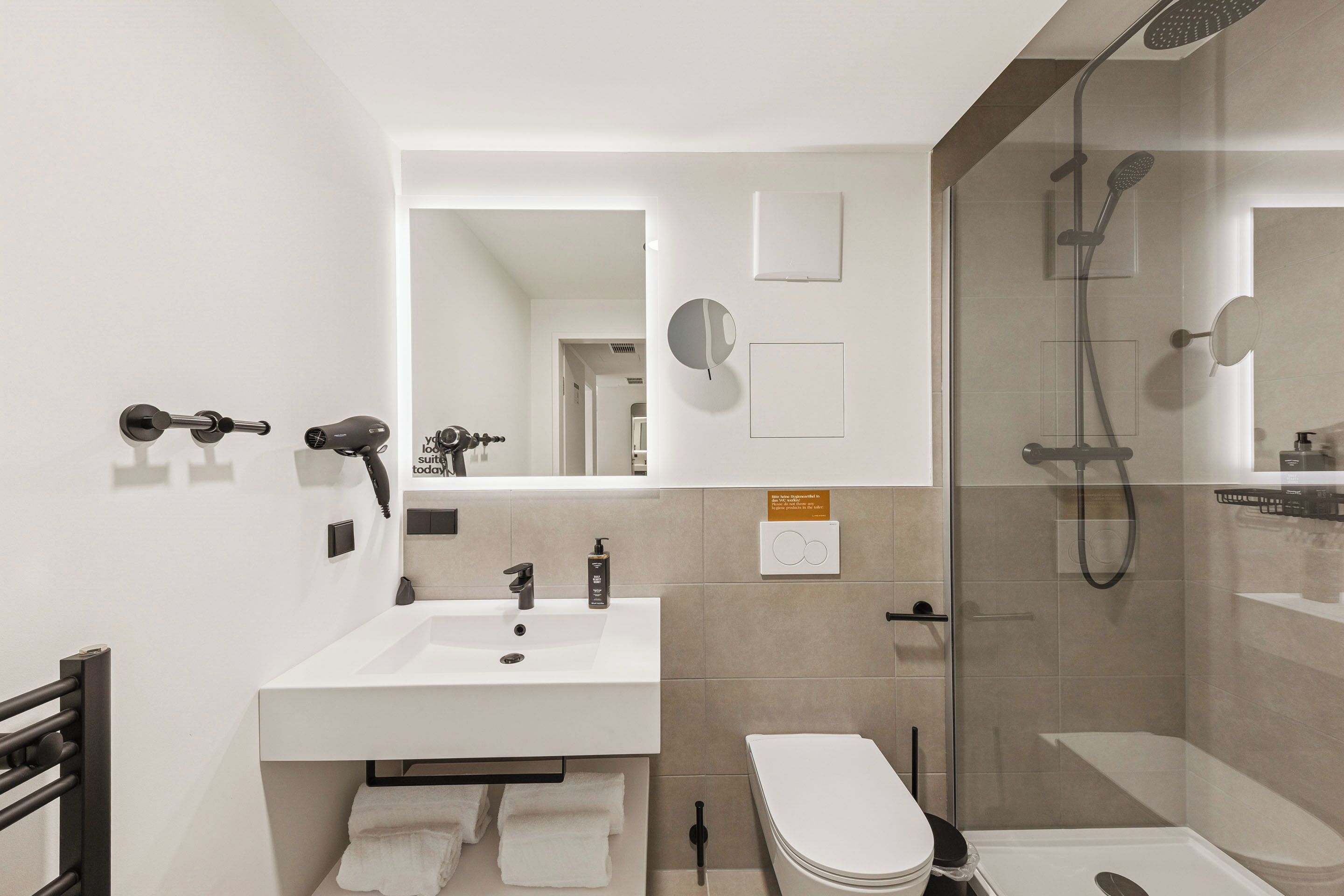 Un baño moderno con lavabo, inodoro y ducha.