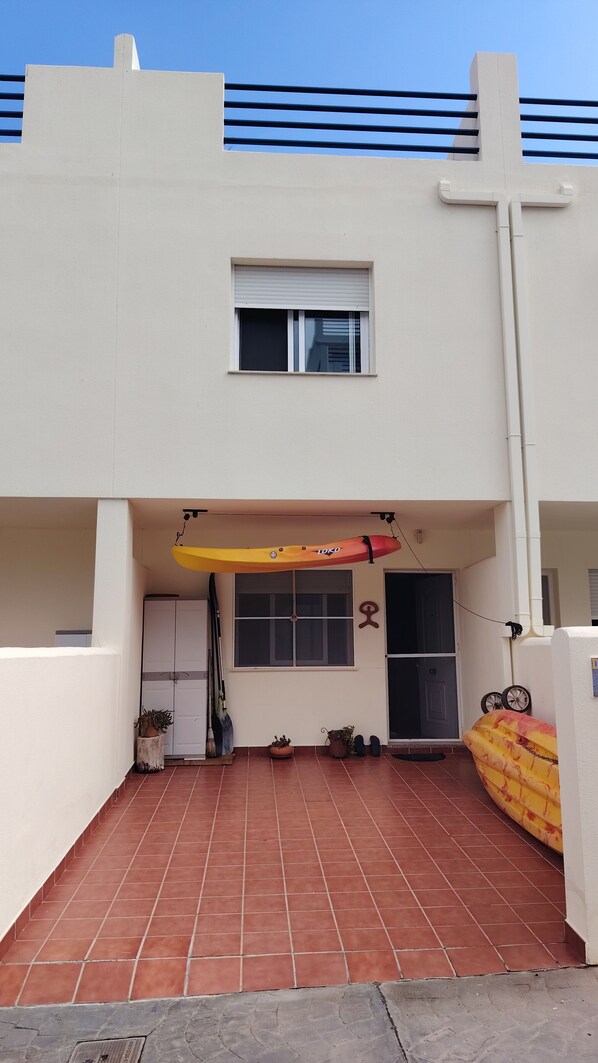 Un immeuble résidentiel doté d’un patio carrelé, d’une fenêtre et d’une porte.