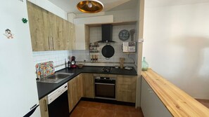 A compact kitchen with a dishwasher, stove, and a wooden countertop. - Casa Luna ;) ... Semi-detached house a few steps from the sea 🌊 (Cuevas del Almanzora)