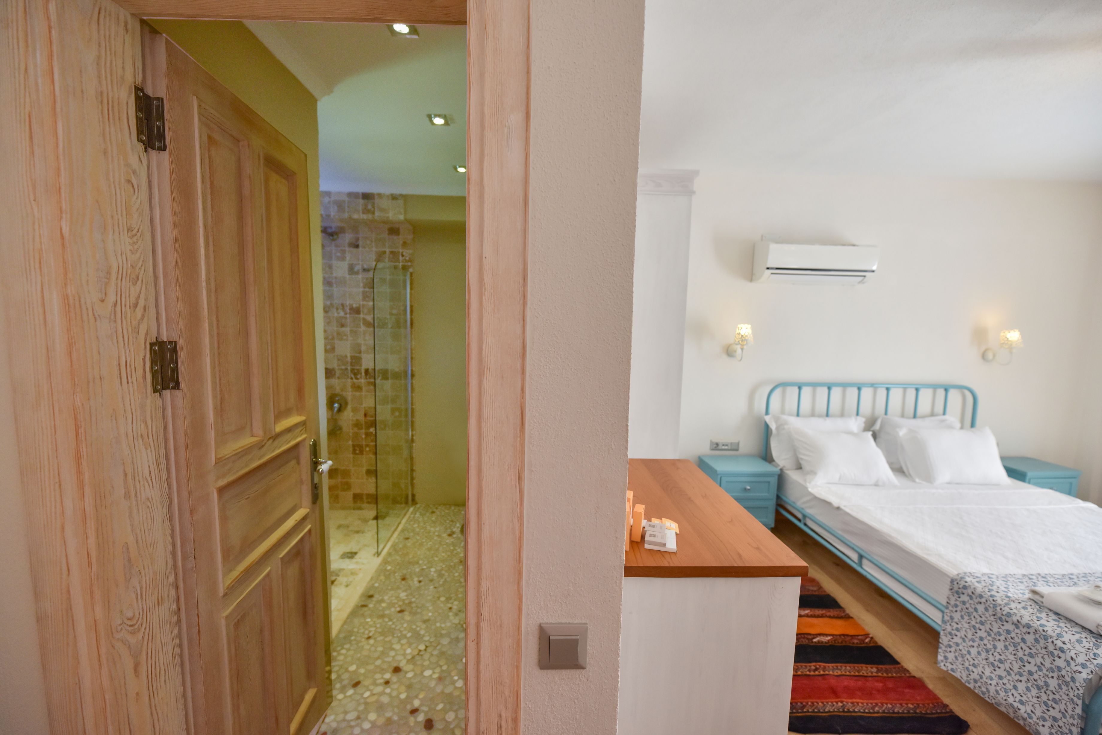 Un dormitorio con cama, mesitas de noche y zona de ducha.