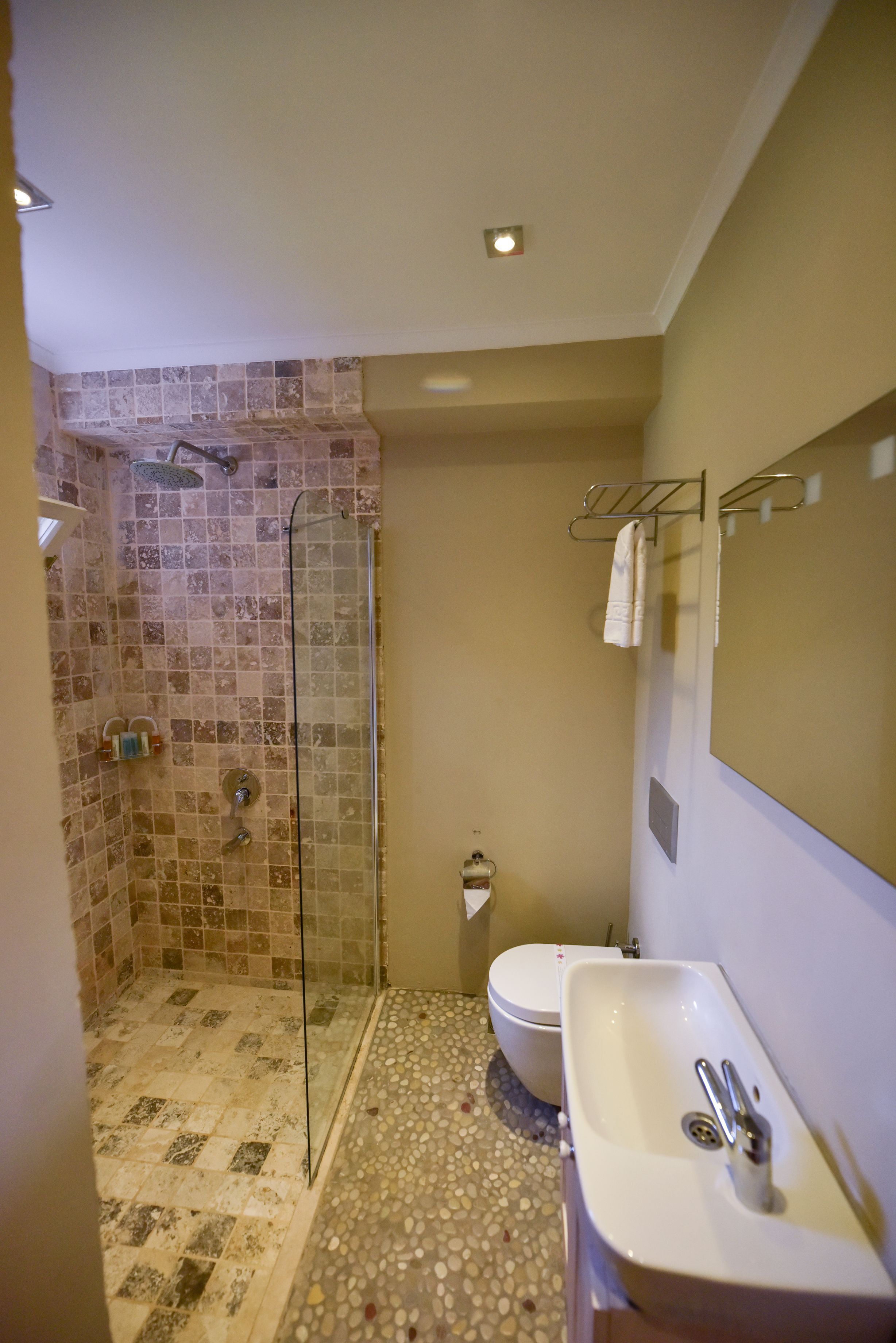 A bathroom with a shower, toilet, and sink.