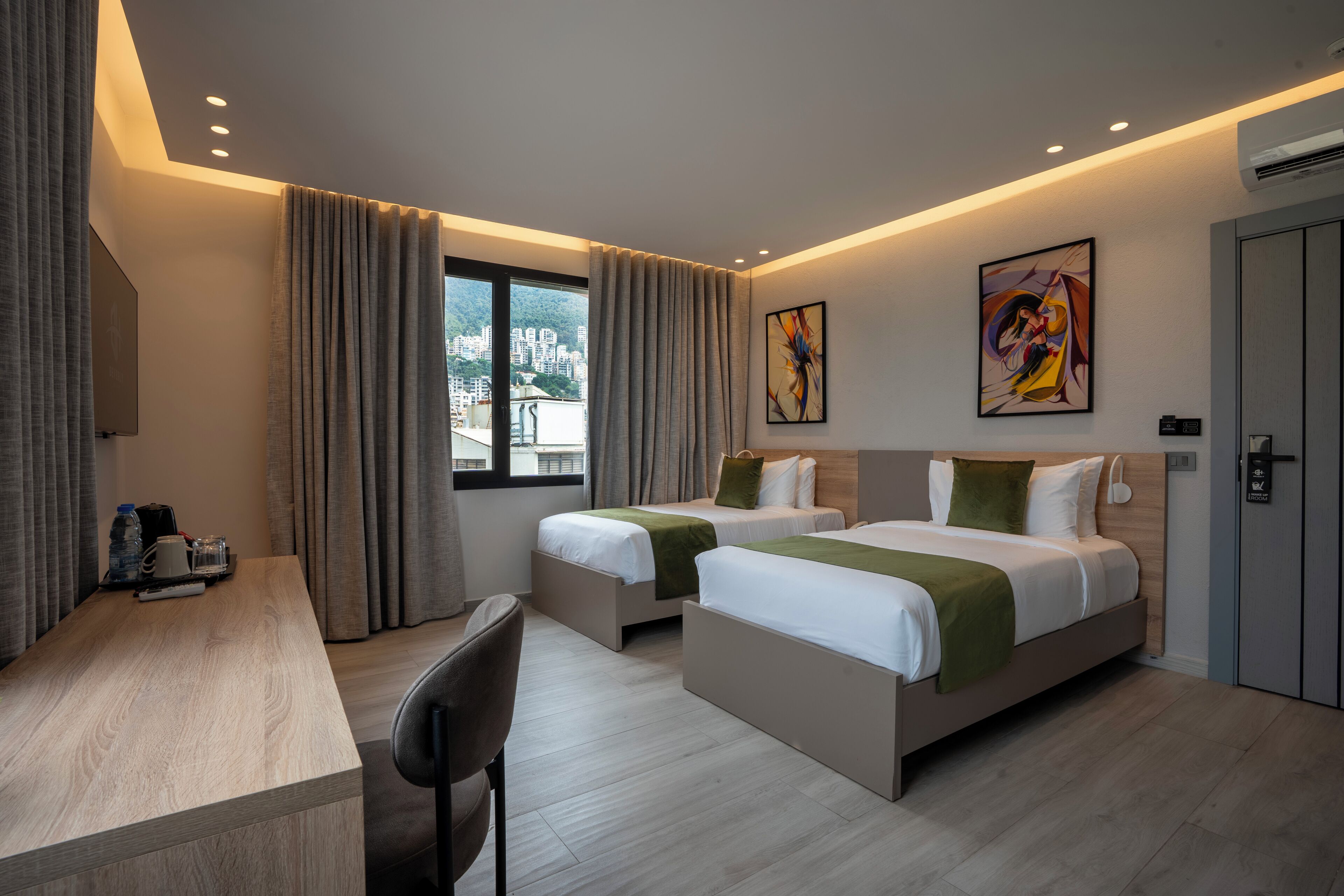 Habitación de hotel con dos camas, un escritorio y una silla.