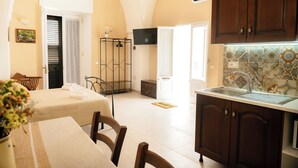 Cocina compacta con lavamanos, armarios y televisor montado arriba.