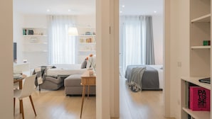 A modern, well-lit bedroom with a bed, bedside table, and a desk with a chair. - Central & White Apartment by Rent all Como (Como)