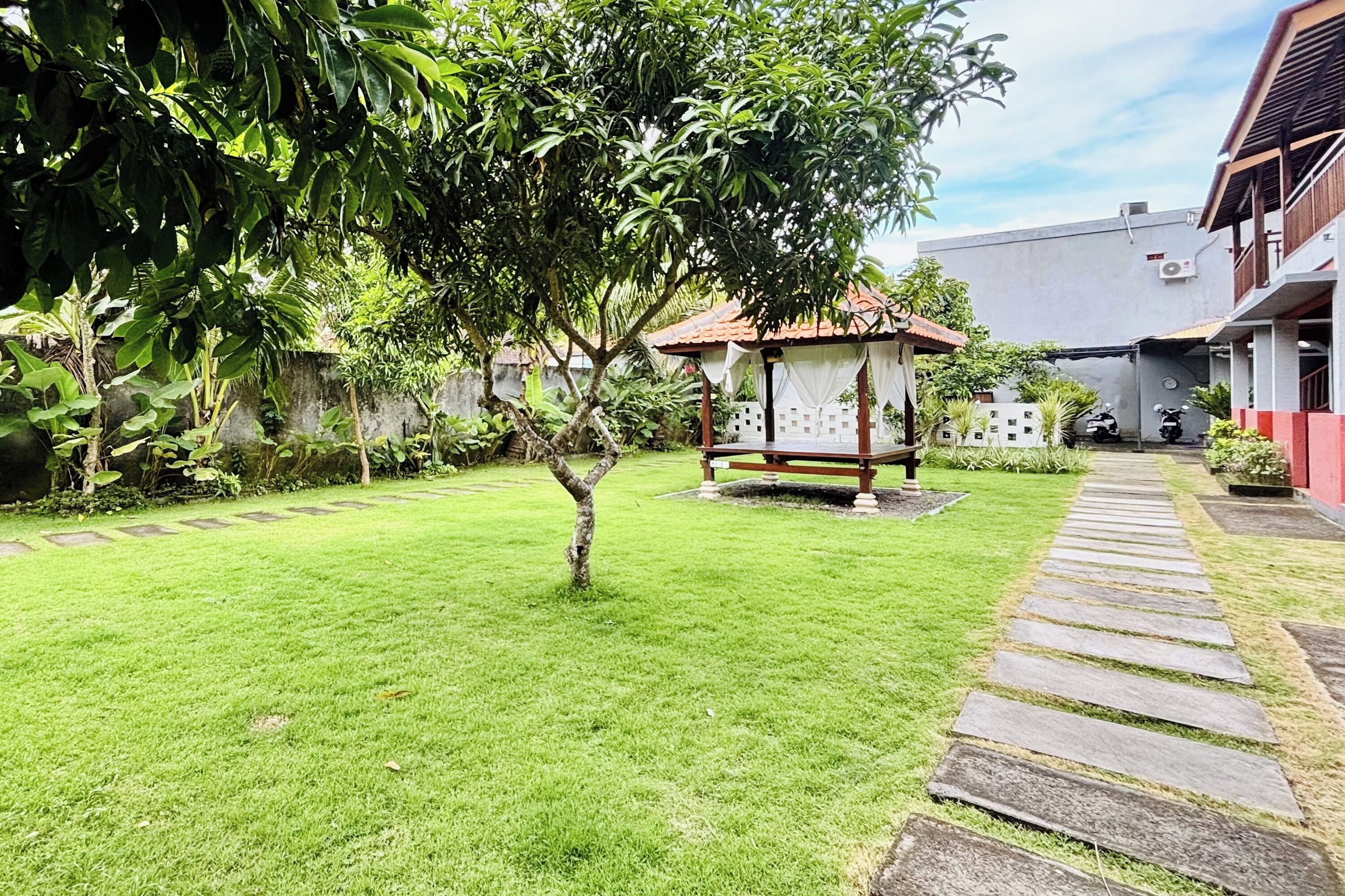A well-maintained garden with a stone pathway leading to a gazebo.