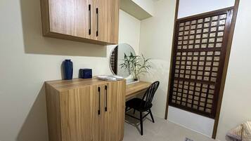 A compact room with a wooden desk, a chair, a potted plant, and a traditional sliding door.