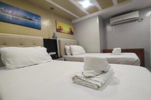 Une chambre d’hôtel avec deux lits, du linge de lit blanc, un tableau au mur et un appareil de climatisation.