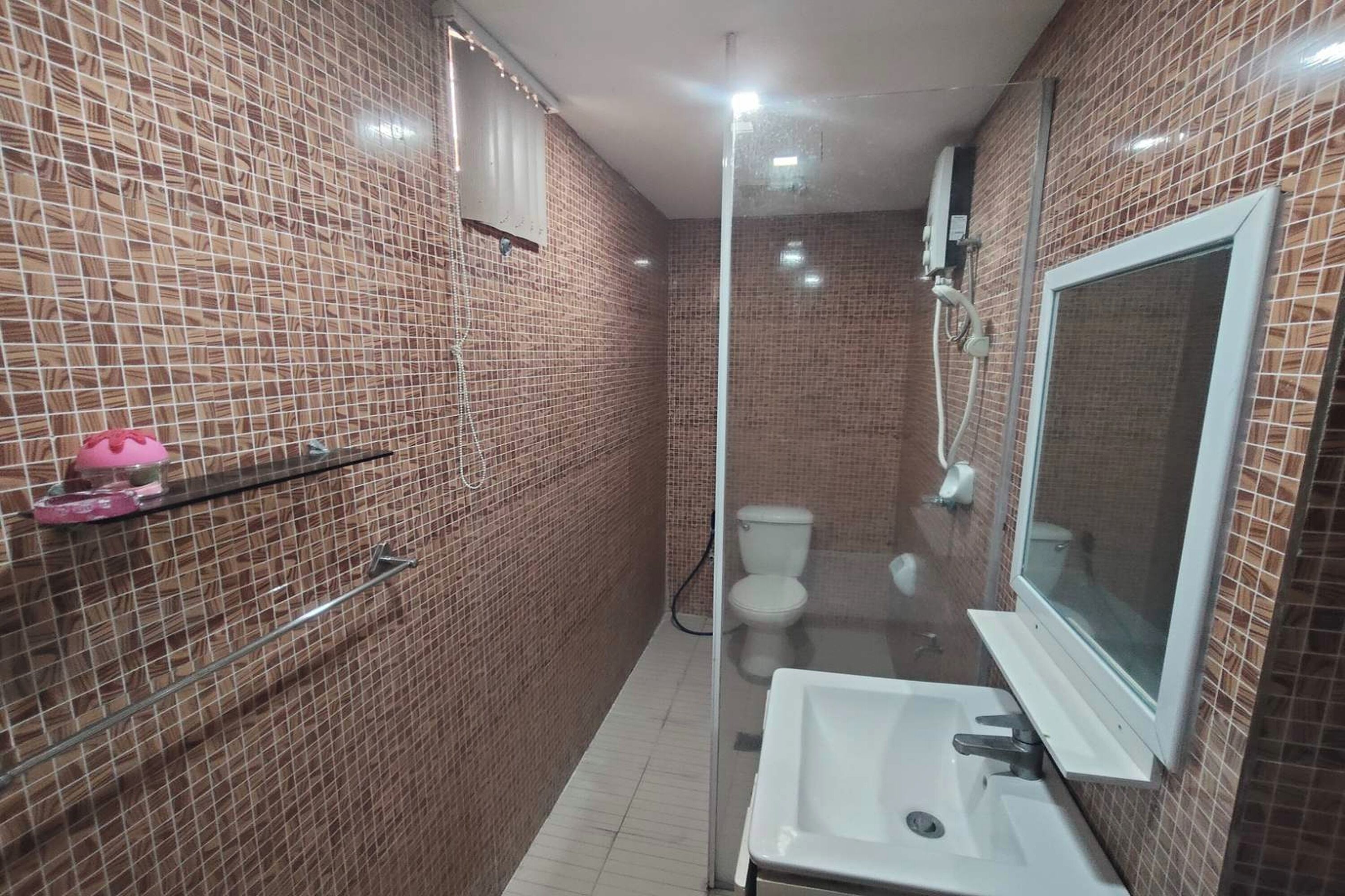 A bathroom with a glass shower enclosure, a white sink, and a mirror.