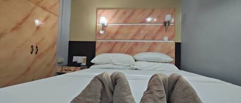Habitación de hotel con cama, mesita de noche y armario.