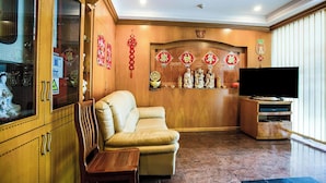 Un salon avec un canapé, un meuble en bois et un téléviseur.