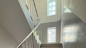 Un escalier avec des rampes et une main courante en métal, menant à l’étage supérieur.
