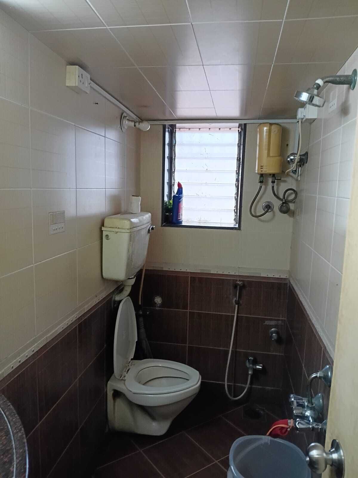 Un bagno piccolo con il water, una finestra, una doccia e un lavandino.