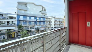 A balcony with a red door, overlooking a row of multi-story buildings with balconies, some with plants. - Lovely apartment in Chioggia with WiFi (Chioggia)