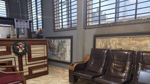 Un hall d’entrée avec un comptoir de réception, des sièges en cuir et des œuvres d’art accrochées aux murs.
