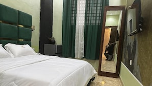 Une chambre à coucher avec un lit, un miroir et une porte donnant sur une autre pièce.