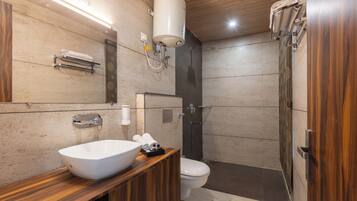 Une salle de bain moderne avec un meuble-lavabo en bois, un lavabo blanc, des toilettes et un espace douche.