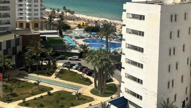 A hotel with a pool, palm trees, and a view of the beach and ocean. - Luxurious sea view (Sousse)