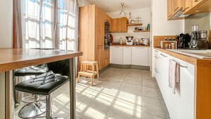 Una cocina moderna con armarios de madera, horno empotrado, cafetera y lavabo.