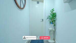 A hallway with a door marked for women, a potted plant, and a decorative column. - Stylish Urban Studio in Sheffield –  APT 21 (Sheffield)