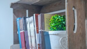 Una estantería con libros y una pequeña planta en maceta.