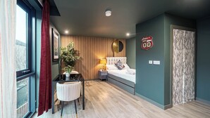 A modern bedroom with a bed, bedside table, lamp, and a potted plant. - Boutique Studio with Designer Finishes – APT 16 (South Yorkshire)