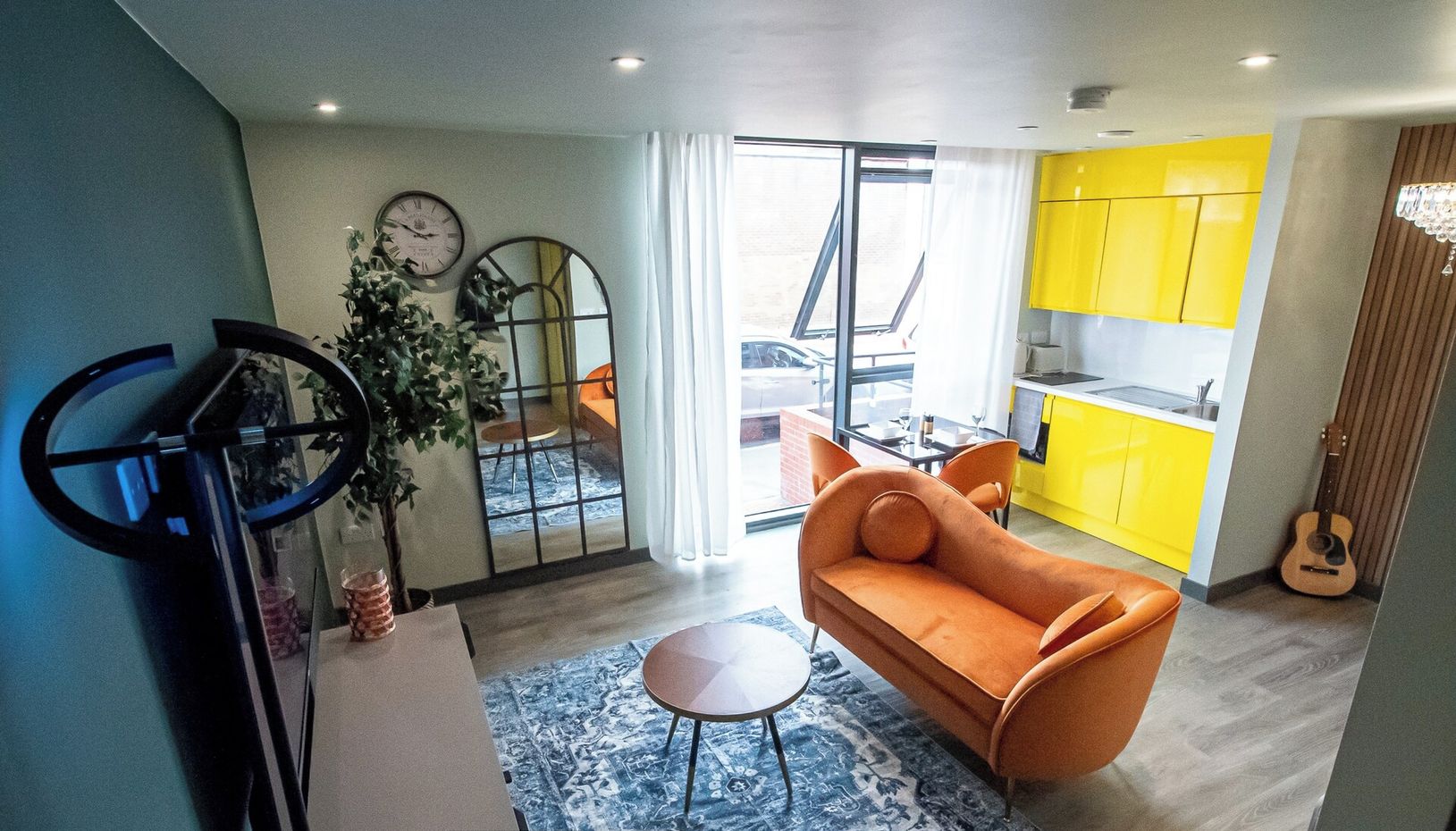 A modern apartment with a living room, kitchen, and dining area.