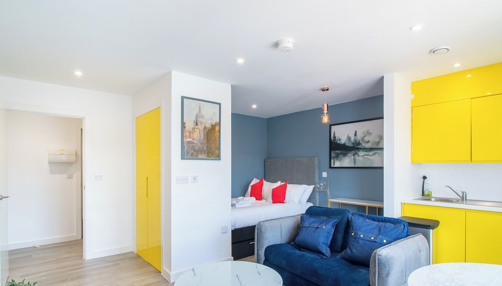 Ein modernes Apartment mit Bett, Sofa und Küchenbereich.